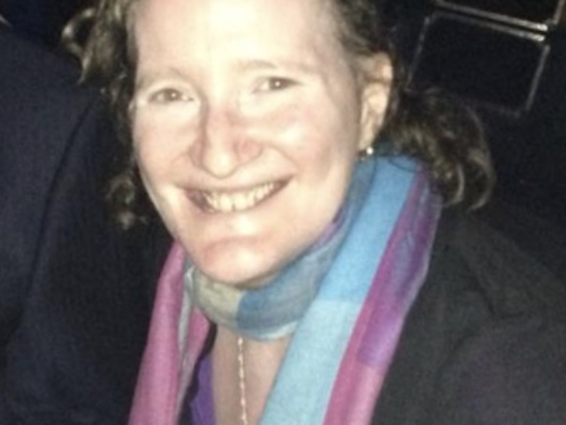 Rhonda smiling at camera with a pink and blue scarf.