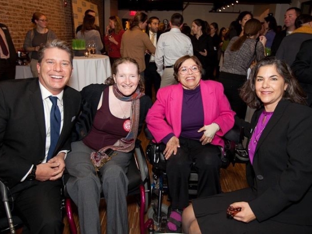 4 smiling international development colleagues at HI event.