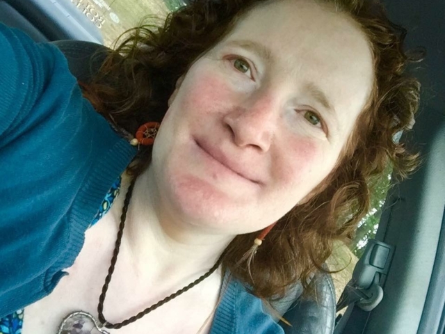 Rhonda smiling at the camera, wearing a heart pendant.