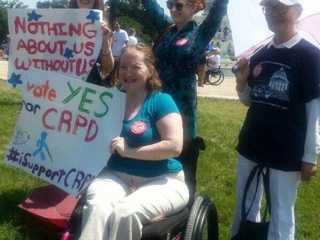 Rhonda, Yoshiko Dart and colleagues holding up signs in support of CRPD ratification