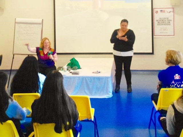 Rhonda speaking holding a microphone in front of a group of women with disabilities in Oaxaca, Mexico. 2018.