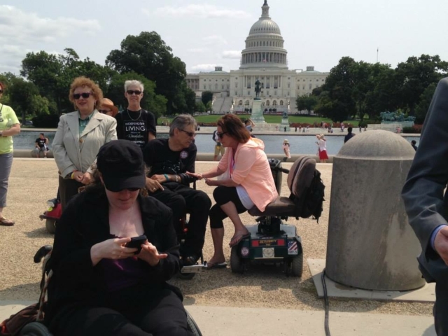 Rhonda looking down at her phone in front of the US Capitol - always active on social media!