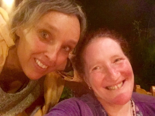 Two women smiling at the camera with big smiles.