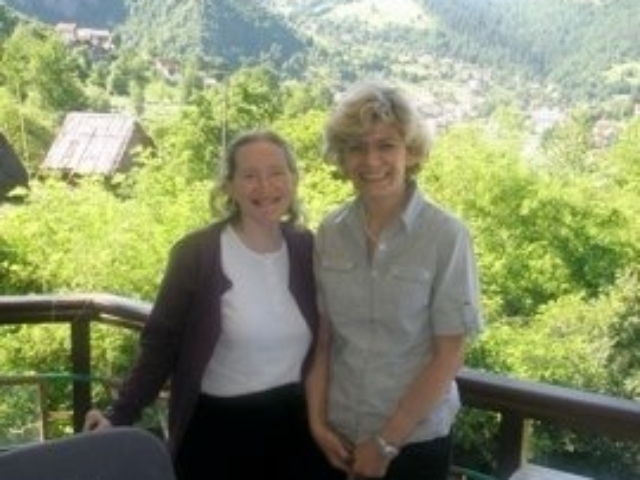 Rhonda with colleague in front of a green mountain in Bosnia.