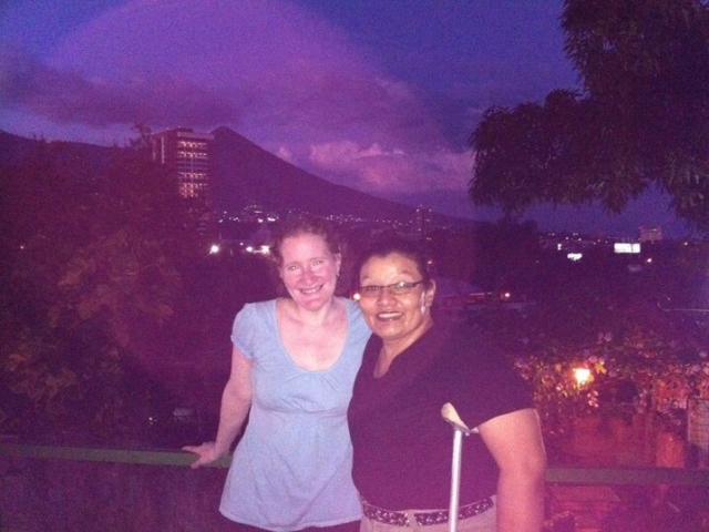 Rhonda and colleague standing in front of a volcano and San Salvador, El Salvador.