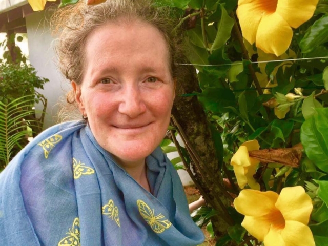 Rhonda with yellow tropical flowers and plants