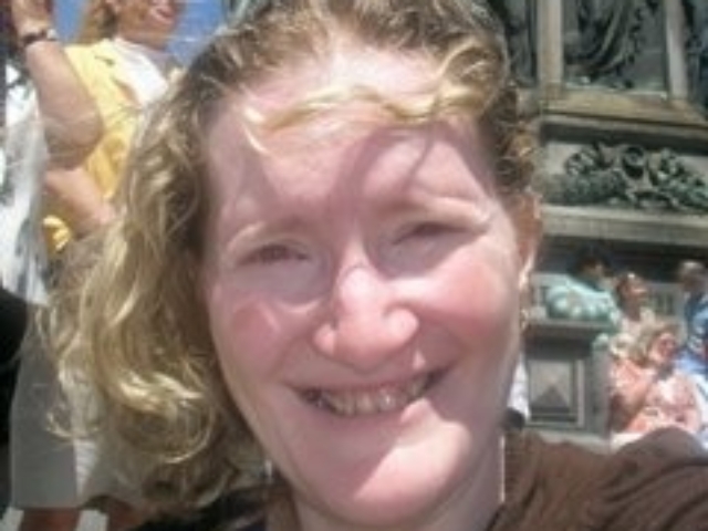 Rhonda smiling in front of a statue in Vienna.