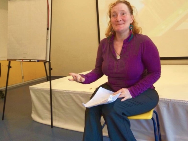 Rhonda training. She is gesturing with her hand and is engaging the group.