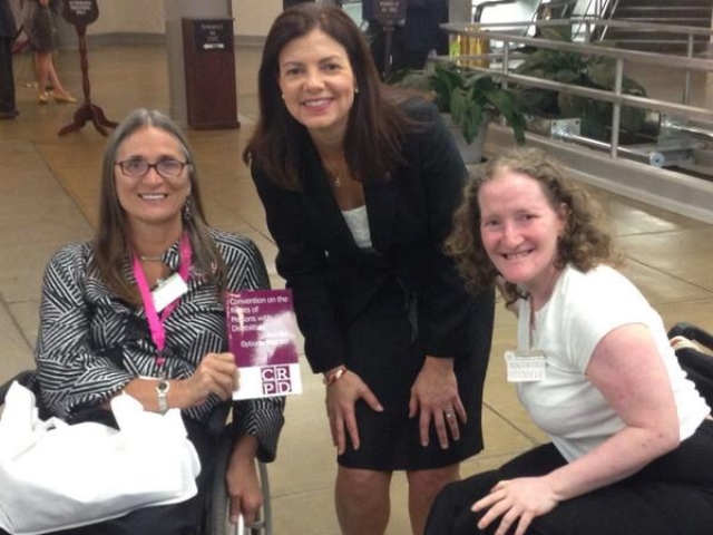 Marca Bristo and Rhonda speaking with Senator Ayotte in the Senate tunnels. Marca holds CRPD publication.