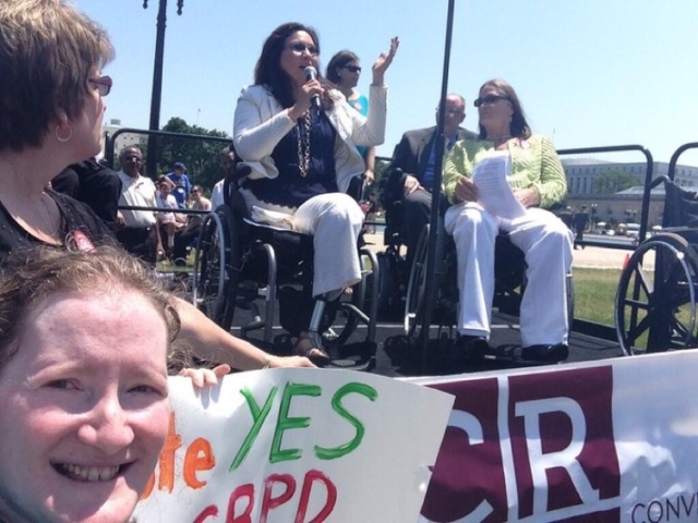 Rhonda in front of Senator Duckworth speaking on beahlf of CRPD ratification.