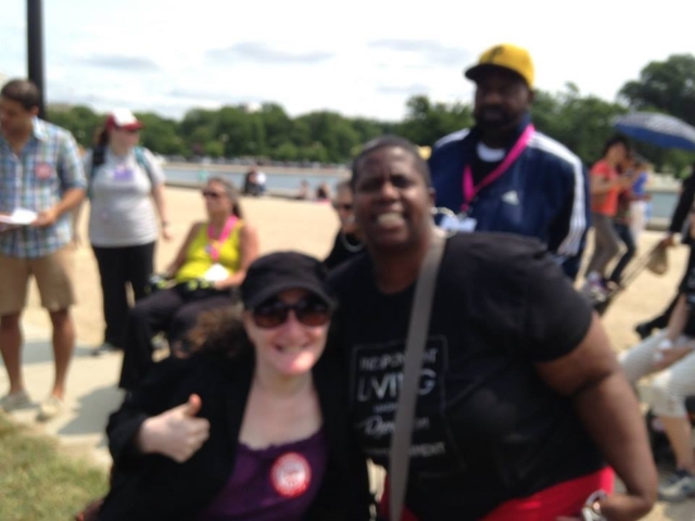 Rhonda with colleague at CRPD rally. Rhonda is giving the thumbs up and is wearing a CRPD sticker.