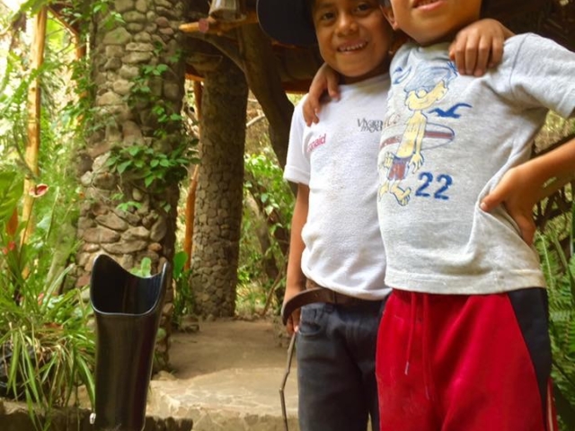 Two boys in Guatemala - arm in arm - standing next to Rhonda's prosthetic legs.