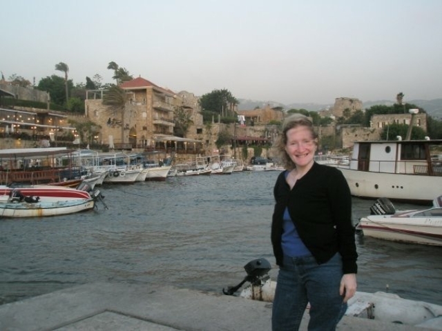 Rhonda in front of a Lebanese port, boats and buildings.